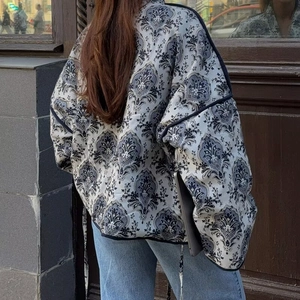 Rear view of loose paisley print jacket with navy trim and V-neck tie detail