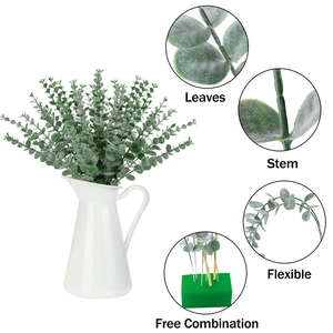 Detail view of artificial eucalyptus leaves and flexible stems in white ceramic vase