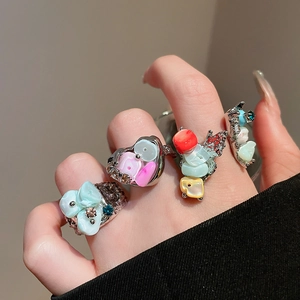 Detailed close-up of a silver ring set with colorful shell pieces and crystals