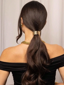 Detailed view of golden metallic hair tie with brushed texture on a low ponytail hair style