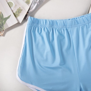 Detailed flat lay of light blue athletic shorts featuring elastic waist and white piping