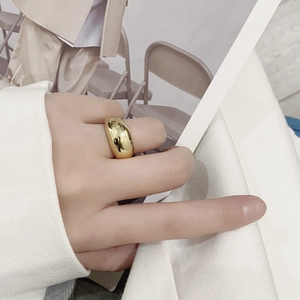 Detailansicht eines polierten goldenen Kuppelrings am Finger mit glänzender Oberfläche