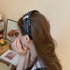 Gros plan du bandeau en tissu paisley noir avec étiquette fait main sur un modèle