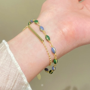 Dettaglio bracciale vintage francese a doppio strato con catena dorata e perle in smalto colorato