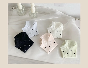 Detailed flat lay of polka dot no-show socks in various pastel colors and soft cotton fabric