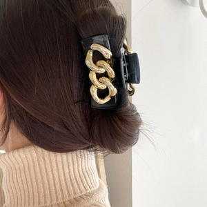 Elegant black claw clip for women featuring a gold metal chain design in a square shape