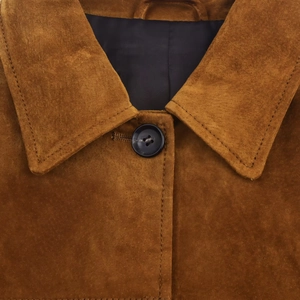 Détail d'une veste en daim marron avec col à revers et boutons en résine mate