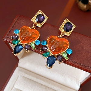 Gros plan détaillé de boucles d'oreilles vintage avec cœurs orange et gemmes multicolores