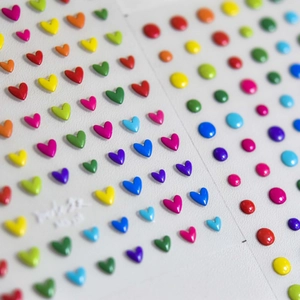 Close-up of 3D colorful heart nail art stickers with glossy embossed texture