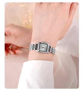 Detail of GEDI square silver watch featuring Roman numerals and polished steel link strap