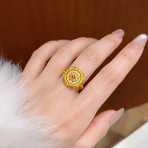 Détail d'une bague vintage en or avec rubis central et gravures royales sophistiquées