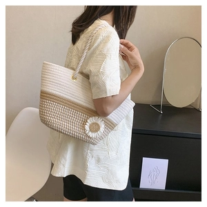 Detail of woven tote bag with sunflower accent and thick rope shoulder strap