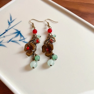 Gros plan de boucles d'oreilles fleurs rétro sur une assiette en porcelaine de style chinois
