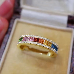Detailed close-up of a gold ring featuring rainbow zircon stones and micro-pave crystals