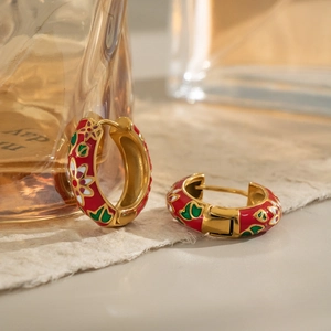 Golden stainless steel hoop earrings with colorful floral enamel patterns in a warm setting