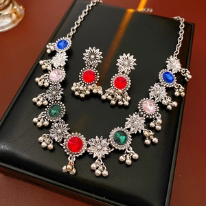 Close-up of vintage flower jewelry set with colorful rhinestones and bell pendants