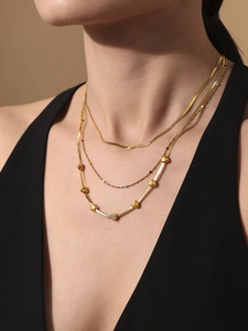Detailed view of triple-layered 18K gold plated heart pendant necklace on a model