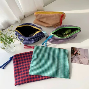 Classic checkered makeup bags in various colors with decorative woven zipper pulls