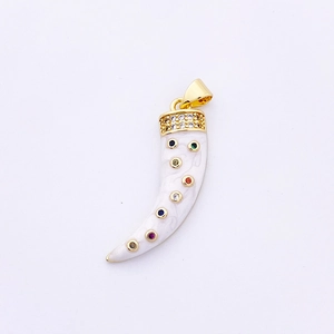 Détail macro d'un pendentif cornicello doré avec texture marbrée et zircons colorés