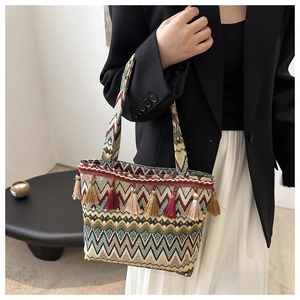 Detailed view of bohemian woven tote bag with colorful geometric patterns and fringe