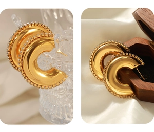 Makroaufnahme von 18K Gold C-Ohrringen mit einer Reihe von eingelegten Zirkonia-Steinen