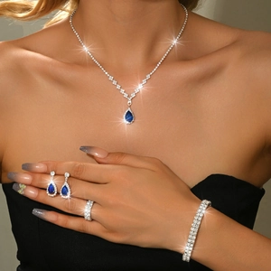 Detailed close-up of blue teardrop zircon necklace and earrings on a model with sparkling effects