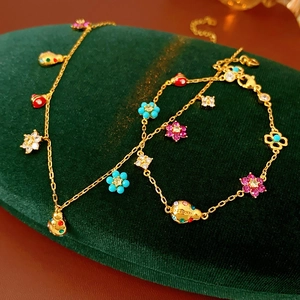 Close-up of gold ladybug and flower enamel charms with rhinestones on velvet
