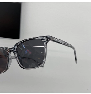 Gros plan détaillé des charnières de lunettes de soleil grises et texture grain de bois