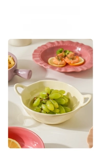 Detail of cream ceramic double-ear bowl and wavy pink plate for salad and ramen use