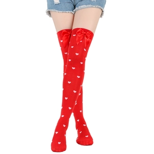 Detail of red over-the-knee socks with white hearts and decorative bows at the top