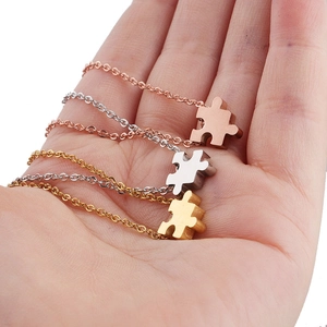Close-up of puzzle piece pendant necklaces in gold, silver, and rose gold finish