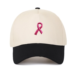 Nahaufnahme der rosa Schleifenstickerei auf einer beige-schwarzen Trucker-Baseballkappe