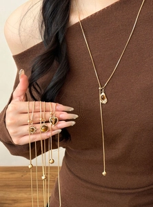Detail of vintage gold tassel necklaces featuring brown tiger eye geometric pendants