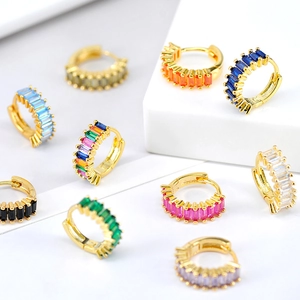 Macro shot of assorted colorful baguette zircon stones on gold huggie earrings set