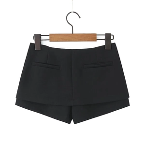 Dettaglio della gonna-pantalone nera a vita alta con design a strati e tasche laterali