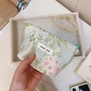 Detail of floral mini pouch with pink cherry blossoms and Simple Wish brand tag