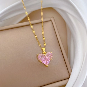 Elegant gold titanium steel heart necklace with pink zircon on silk background