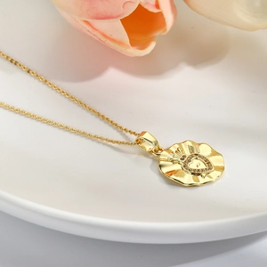 Detail of gold-plated pendant with sparkling zircon heart and crown on a white plate