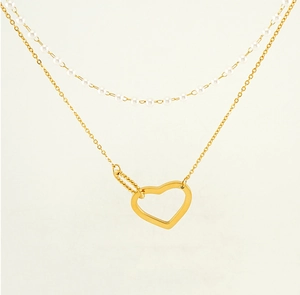 Detail of double-layer gold necklace with heart pendant and elegant pearl strand