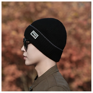 Close-up of black ribbed knit beanie featuring an NY&JA label for winter warmth