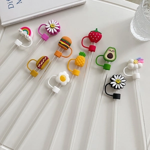Close-up of colorful PVC straw toppers featuring daisy, rainbow, and fruit shapes