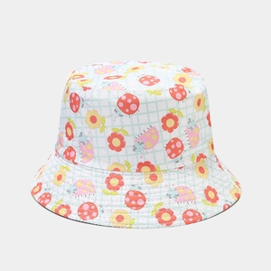 Gros plan du chapeau bob en coton avec motifs coccinelles et fleurs jaunes sur fond quadrillé