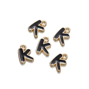 Detailed close-up of five black enamel gold-rimmed letter K charms for DIY jewelry making