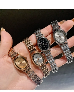 Hand holding four elegant women's oval quartz watches in gold and silver finishes