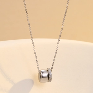 Collier en acier inoxydable argenté avec pendentif cylindrique serti de zircons