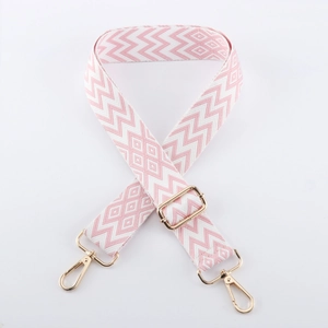 Detail eines pink-weißen Jacquard-Taschenriemens mit goldenen Karabinerverschlüssen