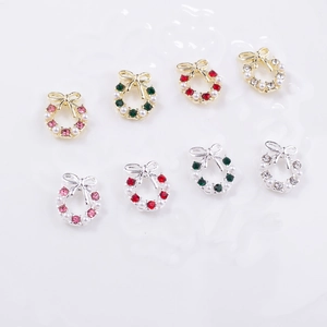 Close-up of alloy Christmas wreath nail charms with bow, pearls and colorful rhinestones