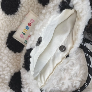 Detail of polka dot plush bag with satin lining and snap button closure