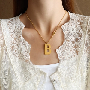 Collier à billes doré avec pendentif lettre B et élément décoratif épingle de sûreté