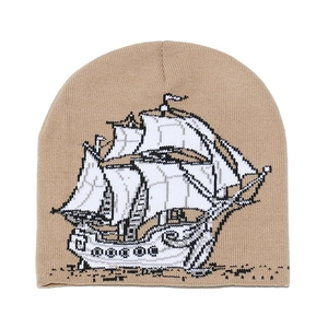 Détail du motif jacquard de voilier sur un bonnet en maille de couleur beige
